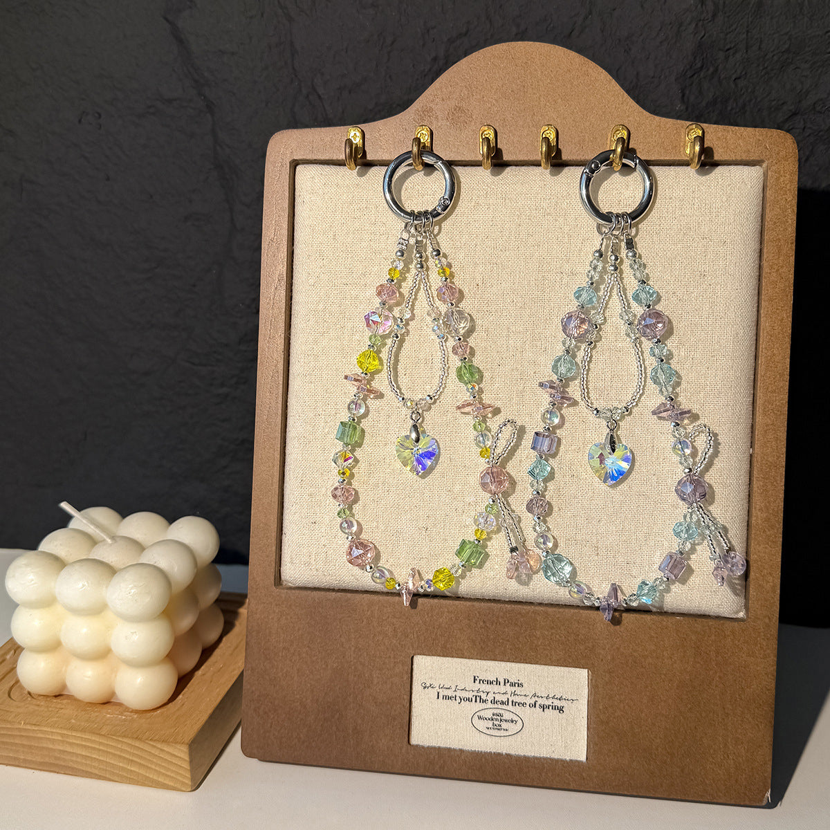 Beaded phone straps displayed on a wooden stand